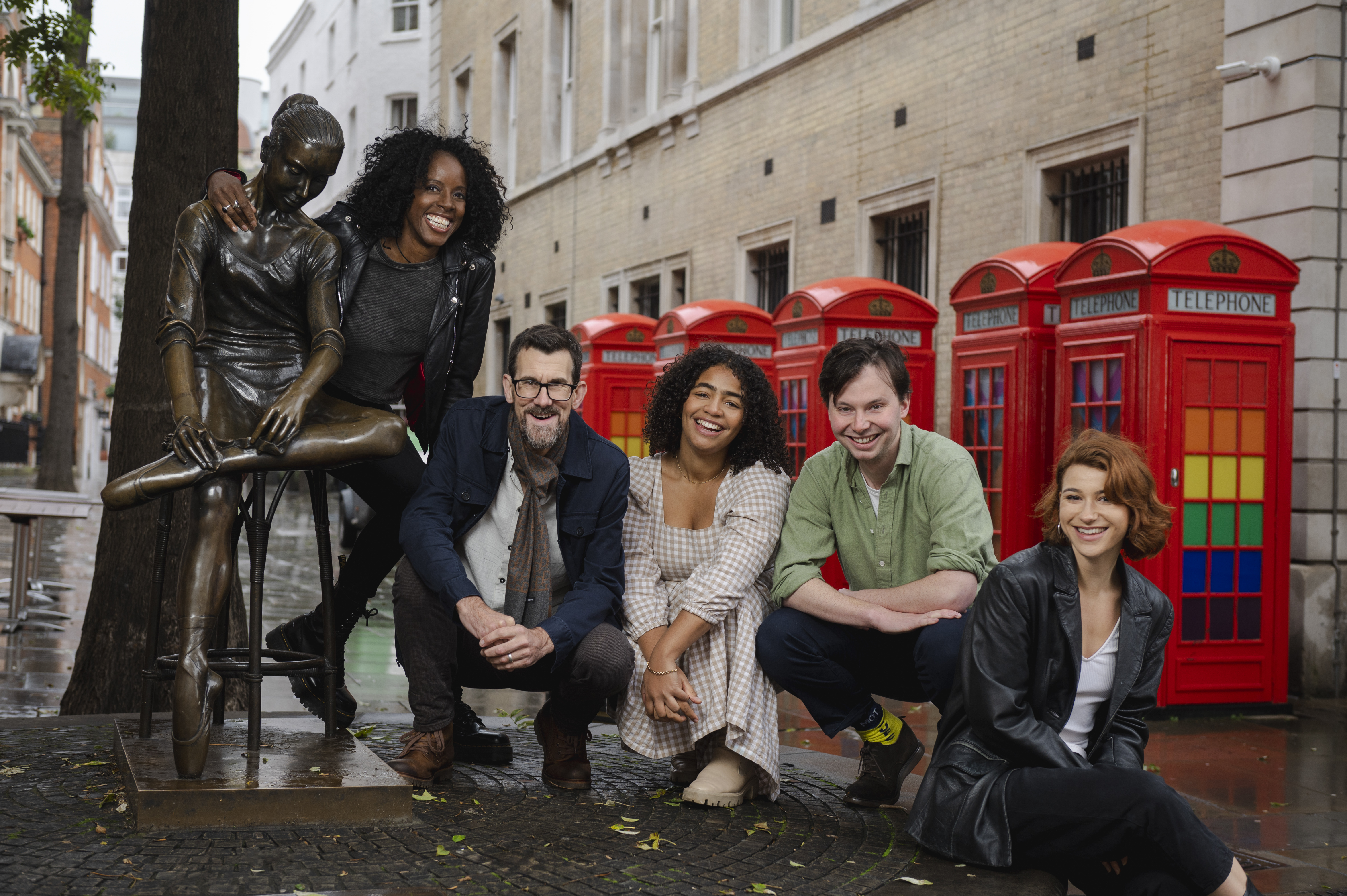 Photos of five actors posing on London street in front of red phone booths.