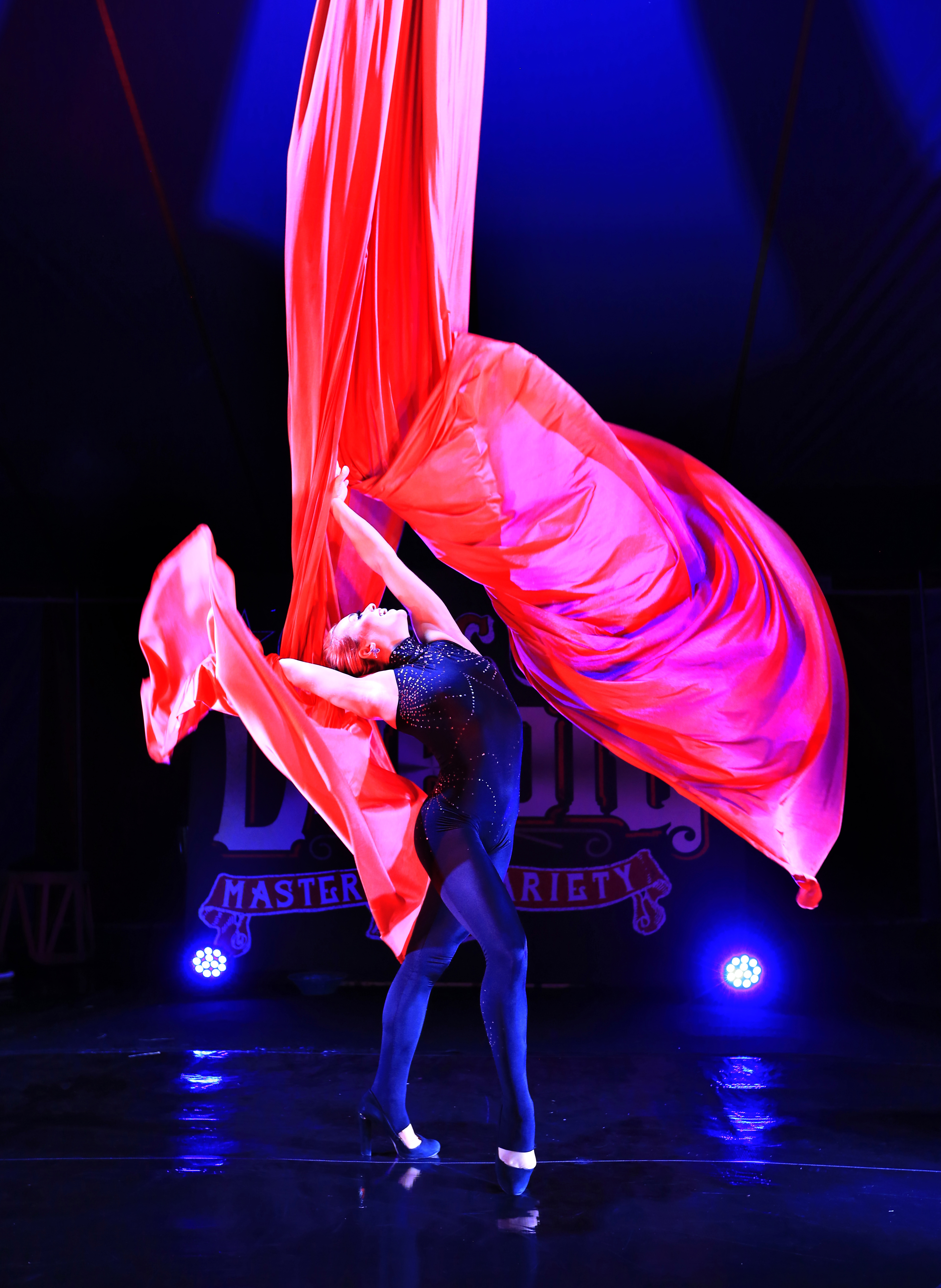 Photo of The Great DuBois member dancing with large red ribbon.
