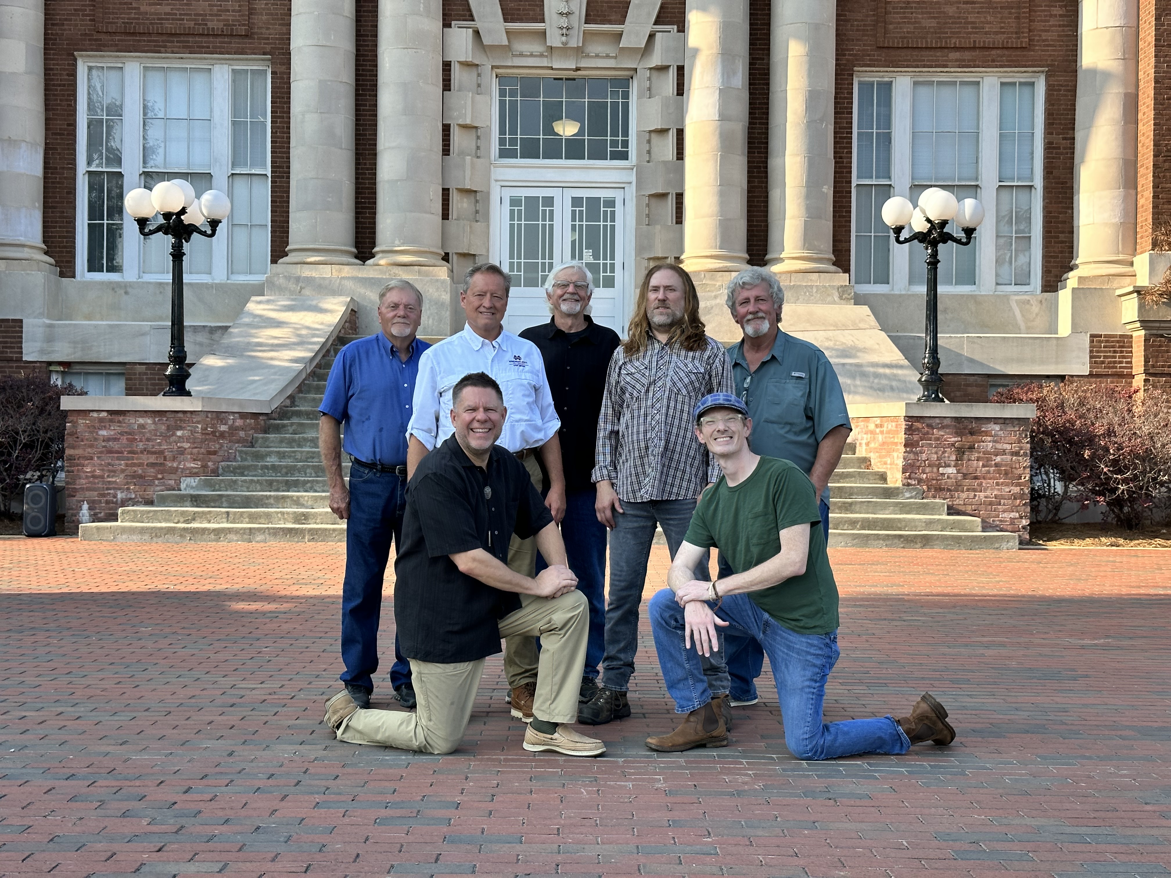 Photo of 7 men in business casual, standing in front of Lee Hall